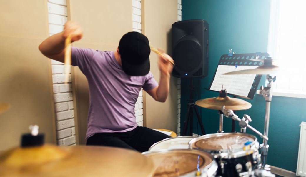 Teen playing drums expressively
