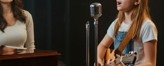 Confident girl singing and playing guitar with instructor
