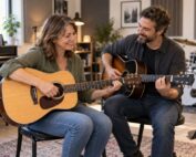 Adult beginner learning acoustic guitar with a music teacher in a Burlington music studio.